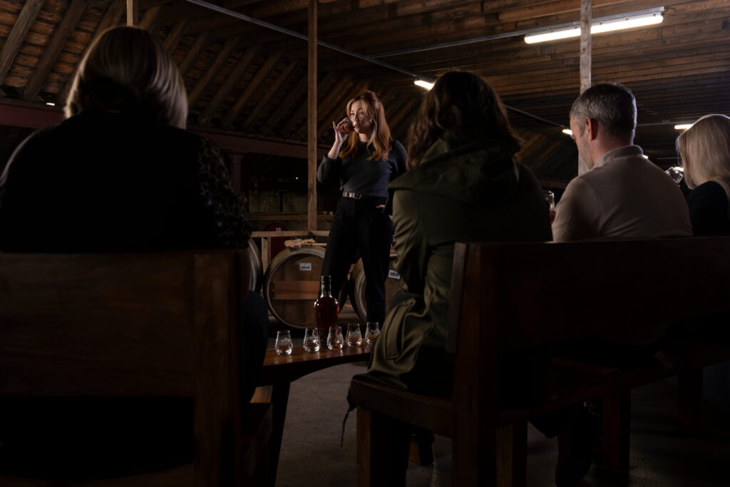 picture of a woman smelling a whisky in a warehouse
